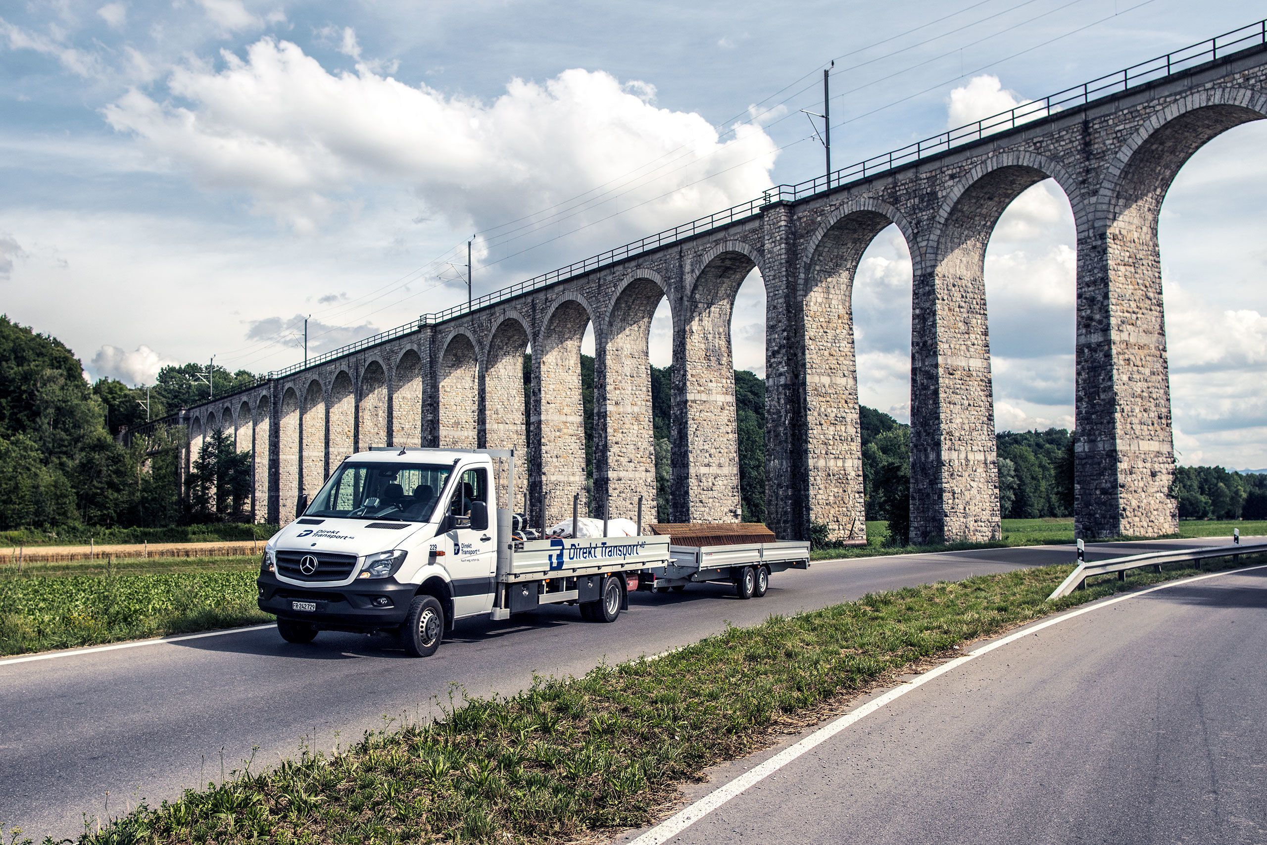 klimaneutrale-transporte-transporter-mit-anhaenger-faehrt-duch-landschaft-obm-bionik-ecovadis.jpg