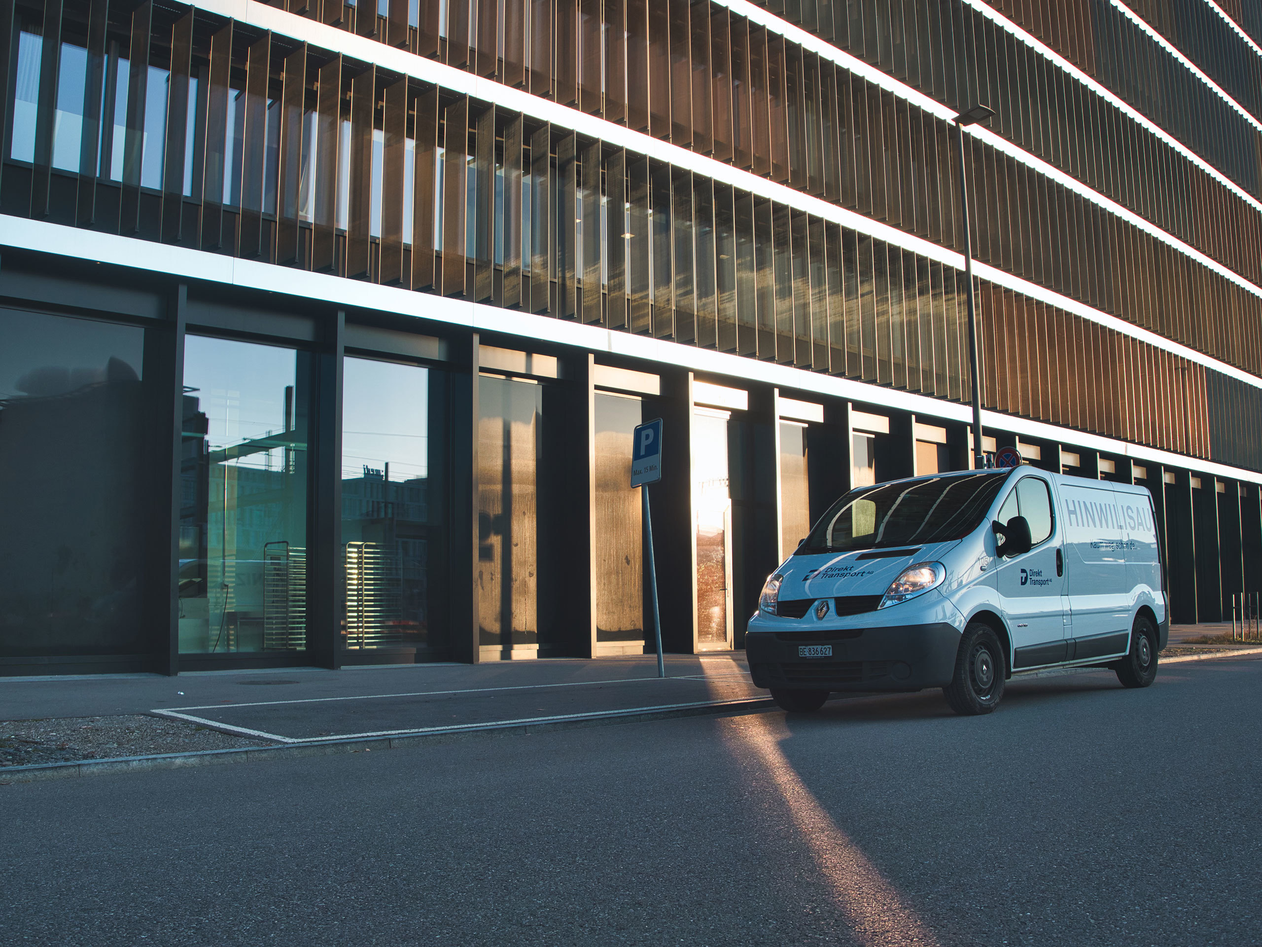 kuriertransporte-fahrzeug-vor-gebaeude-im-morgenlicht.jpg